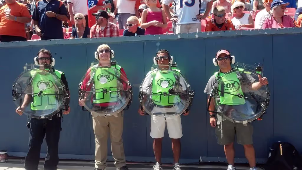 Operators with KLOVER MiK 26 parabolic mics on NFL sideline.