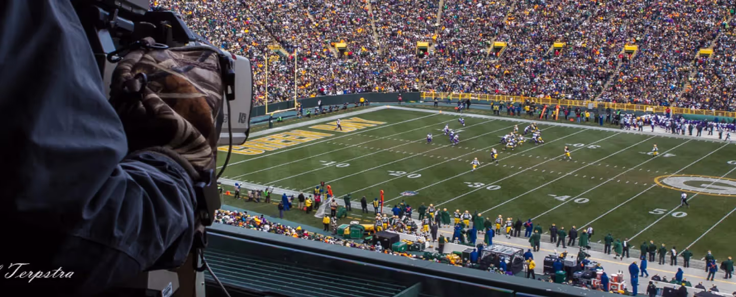 a television camera looking over football stadium 