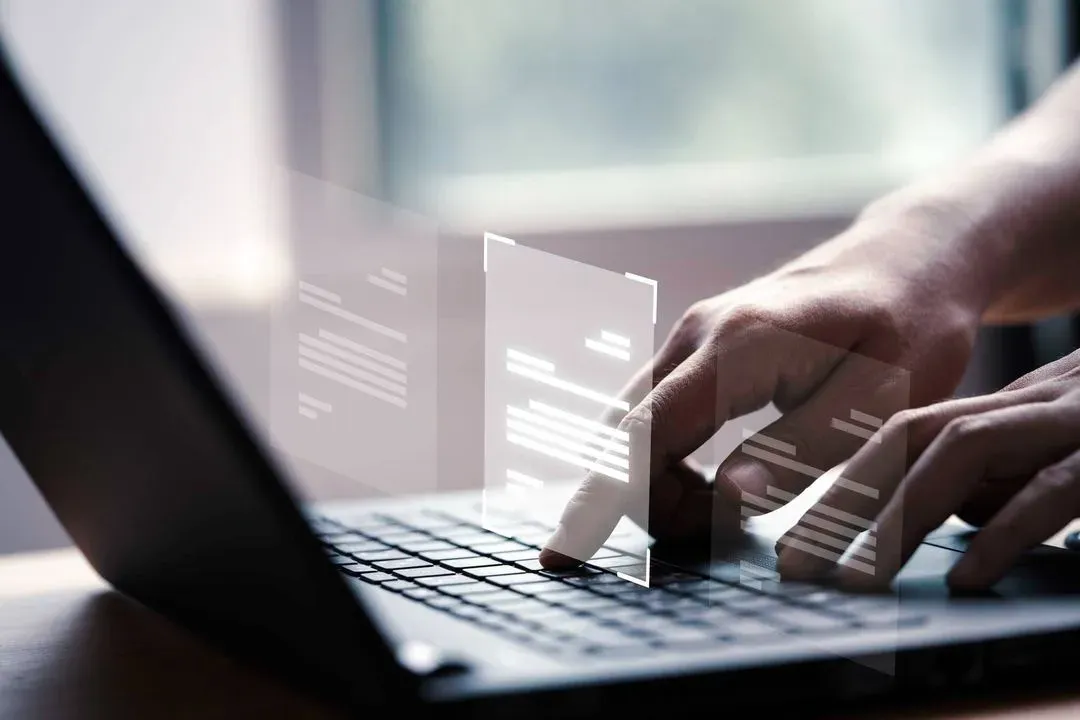 a person typing on a laptop computer with a blurry background